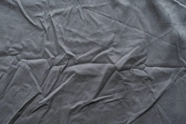 Abstract pattern of a gray crumpled bed sheet in bedroom. Gray wrinkled fabric texture rippled surface, Close up bed sheet in the bedroom after being used.