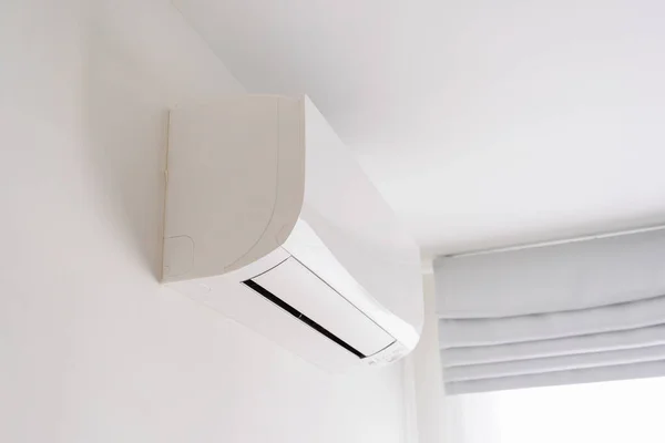 Oda boşluğunda beyaz beton duvarda klima var..