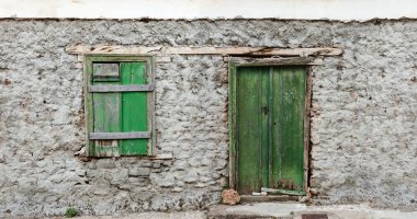 Yeşil boyalı kapı ve pencere, grungy beton duvar yıpranmış.