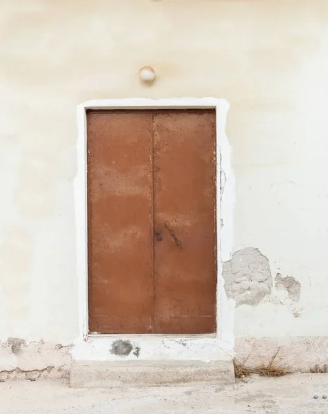 風化した壁に古い茶色塗装金属ドア — ストック写真