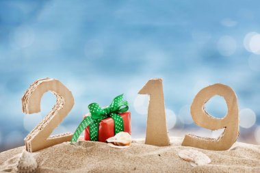2019 el yapımı numaraları yeniden kullanılan karton kağıt hediye kutusu, kum ve deniz arka plan üzerinde ile yapılmış.