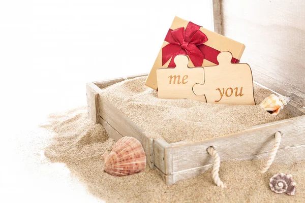 Geöffnete Holzkiste Mit Geschenkbox Und Zwei Puzzleteilen Auf Sand Und — Stockfoto