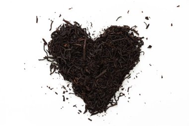Beyaz arka planda siyah kuru çay kalp yapılmış.