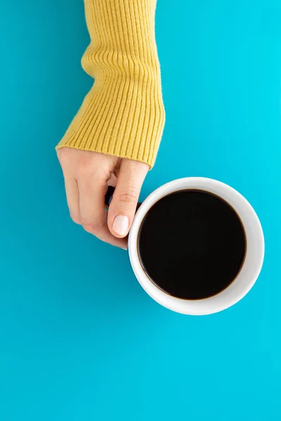 Mano Sosteniendo Una Taza Café Negro Sobre Fondo Azul — Foto de Stock