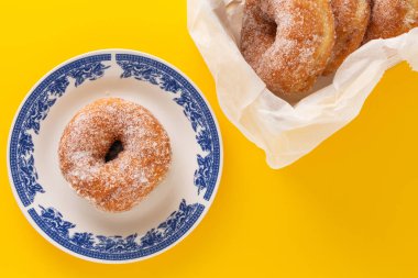 Halka, sarı zemin üzerine bir tabak şeker ile kaplı.