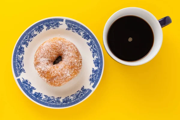 Uma Xícara Café Prato Com Açúcar Revestido Donut Fundo Amarelo — Fotografia de Stock