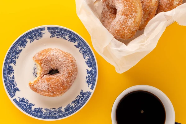 Una Taza Café Plato Con Rosquilla Azucarada Sobre Fondo Amarillo — Foto de Stock