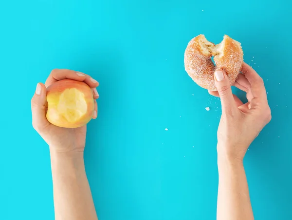 Ręce Trzyma Jabłko Pączka Niebieskim Tle Pojęcie Diety — Zdjęcie stockowe