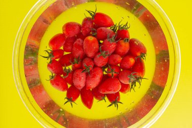 Napa üzüm domates sarı zemin üzerine açık bir kap içinde su closeup içinde demet.