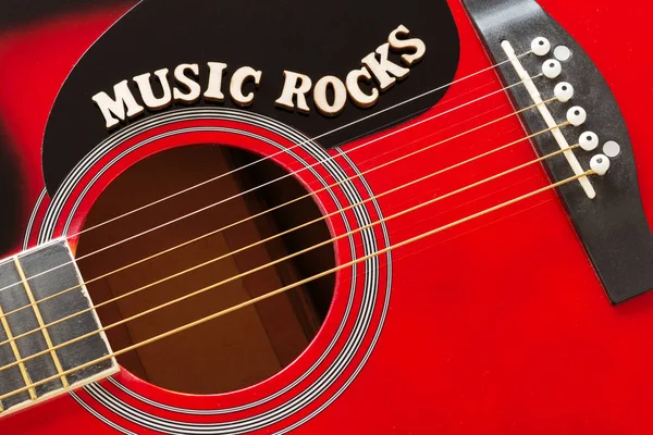 Words Music Rocks med trä bokstäver, närbild på en yta av röd akustisk gitarr. Musik underhållning bakgrund. — Stockfoto