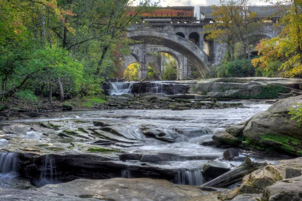庇哩亚秋天的颜色在俄亥俄州瀑布 石拱列车桥梁使一个良好的背景 — 图库照片
