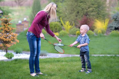 Anne oğlunun badminton oynamak için öğretir. Etkin aile tatil.