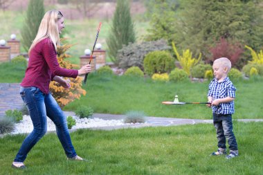 Anne oğlunun badminton oynamak için öğretir. Etkin aile tatil.