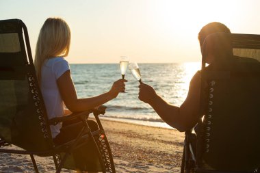  Sevgi dolu bir çift sahilde şampanya içer. Romantik.