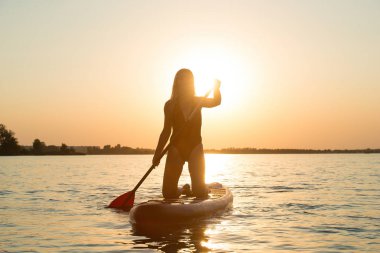 Ayakta yüzen genç seksi kadın. Su sporları, aktif yaşam tarzı..