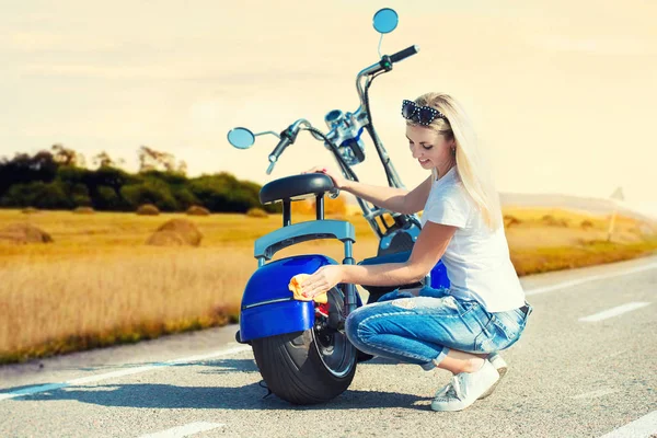 Kız onun motosiklet bir bez ile silinerek.