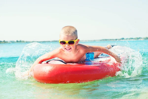 Boy swimming on stand up paddle board.Water sports , active lifestyle.