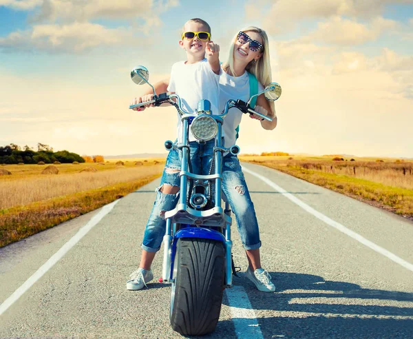 Anne ve oğlu motosiklete biniyor..
