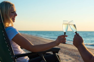 Sevgi dolu bir çift sahilde şampanya içer. Romantik.