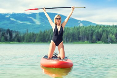 Ayakta yüzen genç seksi kadın. Su sporları, aktif yaşam tarzı..