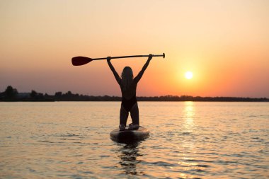 Ayakta yüzen genç seksi kadın. Su sporları, aktif yaşam tarzı..