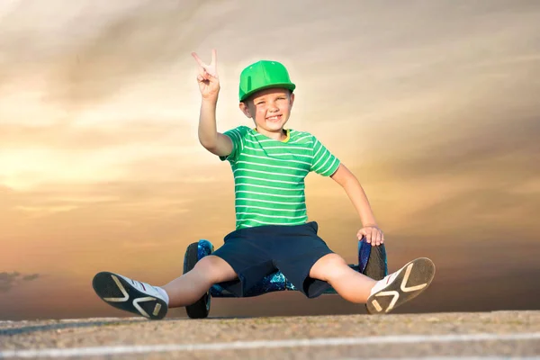 The boy is riding on a balance board.The guy is sitting resting.