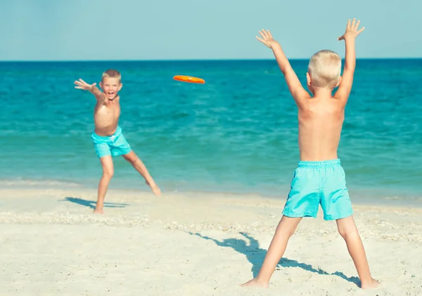 兄弟们在海滩上玩飞盘 — 图库照片