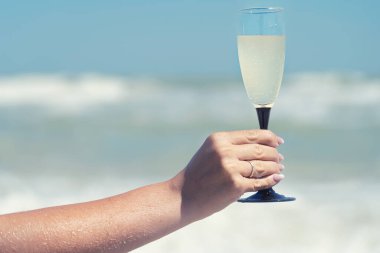  Deniz kıyısında bir bardak şampanya..
