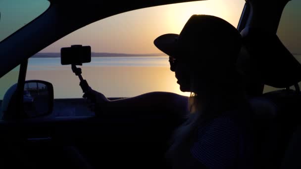 Ung Kvinde Kigger Bilvinduet Solnedgangen Havet Fotograferet Telefonen – Stock-video