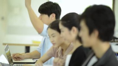 Asya Üniversitesi yaşam kavramı. Asyalı öğrenci ders ve Not almak, dizüstü bilgisayar kullanarak grubu. Öğretmen ve öğretim görevlisi dinlerken gerçek öğrenciler ile kapalı çekilen.