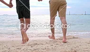 Genç aile kumsalda eğleniyor. Denize birlikte çalışan. 20'li yaşlarda ve bir çocuk beyaz adamla Genç Çinli kadın. Karışık yarış. Ağır çekimde vurdu. Film bak.