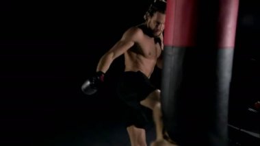 Adam Boks kum torbası. Ağır çekim studio siyah arka plan ile vurdu. 