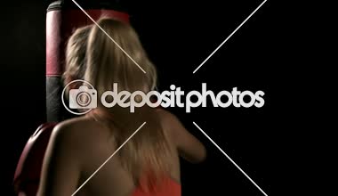 Genç yoğun kadın yumruk atma. Kum delme çanta ve dinlenme. Beyaz genç güzel kadın. Ağır çekimde vurdu. Film bir görünüm filtresi.