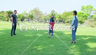 Aile öğleden sonra parkta futbol oynuyor. Genç çocuk ile Alman beyaz erkek ve Asya kadın, parkta birlikte futbol oynayan kız. Hafta sonu aile eğlenceli kavramı.