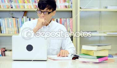 Kütüphane genç öğrenci çalışmada zor. Asyalı erkek üniversite öğrenci kitaplığı kitap ve Resepsiyon ve gülümseyen laptop ile çalışma araştırma yapıyor. Okul eğitim teknoloji kavramı için geri.