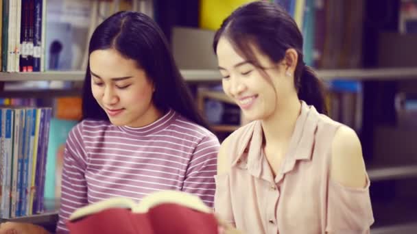 Jonge Vrouwelijke Studenten Lezen Boek Bibliotheek — Stockvideo