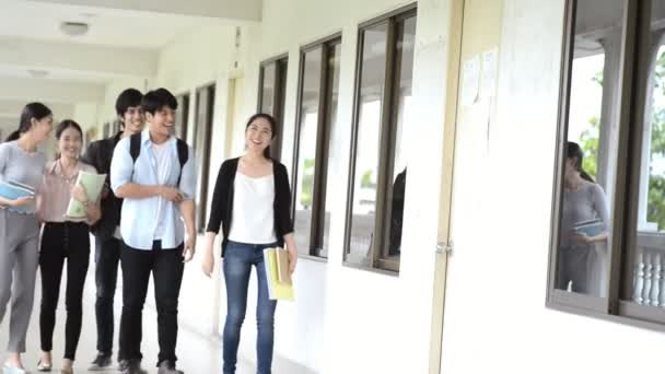Concept de vie universitaire asiatique. Groupe d'étudiants chinois marchant dans la salle de conférence collège étage. Porter des sacs .