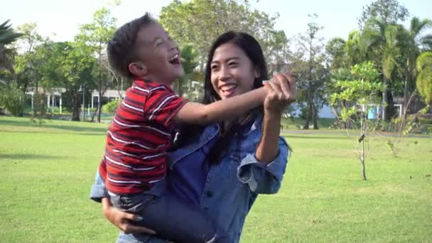 保姆在和一个孩子玩 下午在公园里和一个男孩玩耍的年轻亚洲女人 — 图库视频影像
