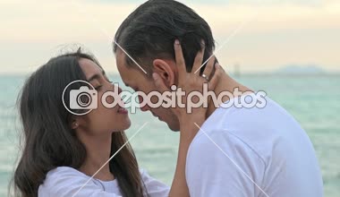 Çekici genç çift romantik sahilde. Tutkulu öpücük güneş sırasında birlikte ayarlayın. Erken 20s beyaz adamla Genç Çinli kadın. Karışık yarış. Ağır çekimde vurdu. Film bak.