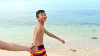 Tayland beach mutlu bir çocuk. Güzel beyaz kum plaj baba elini tutarak çalışan. Tayland seyahat, tatil, tatil molası promosyon için. Ağır çekimde vurdu. POV açı.