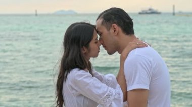 Çekici genç çift romantik sahilde. Tutkulu öpücük güneş sırasında birlikte ayarlayın. Erken 20s beyaz adamla Genç Çinli kadın. Karışık yarış. Ağır çekimde vurdu. Film bak.