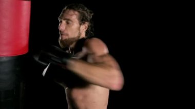 Adam Boks kum torbası. Kırmızı kum torbası şiddetle delme. Beyaz çok uygun delikanlı. Ağır çekimde vurdu. Film bir görünüm filtresi.