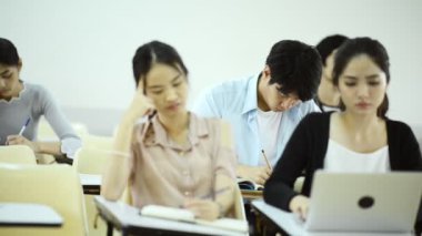 Asya Üniversitesi yaşam kavramı. Genç Asyalı üniversite öğrencilerinin öğrenme, konuşmak ve dinlemek için öğretim görevlisi konferans odasında oturma grubu.