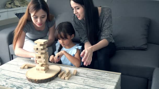 Ung Flicka Spela Spel Med Mamma Och Asiatiska Nanny Vardagsrummet — Stockvideo