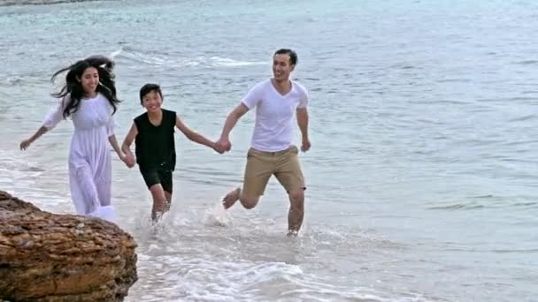 Νεαρή Οικογένεια Έχοντας Διασκέδαση Στην Παραλία Τρέχει Στη Θάλασσα Μαζί — Αρχείο Βίντεο