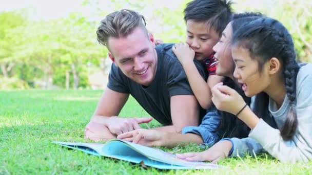 Rodzina Parku Relaks Młoda Rodzina Ustanawiające Trawie Rozmawia Sobą Czytanie — Wideo stockowe