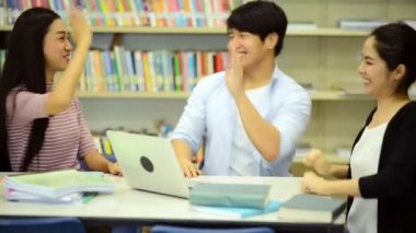Genç öğrenci Kitaplığı'nda çalışmak. Çalışma yaparken mutlu Asyalı kadın ve erkek üniversite öğrencileri araştırma Danışma, kitapları ile kitaplığındaki defter. Okul eğitim çeşitlilik kavramı için geri. 