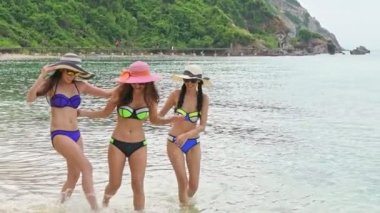 Sahilde güzel Çinli kadın. Grup çekici genç Çinli kadını kumsalda eğleniyor. Yürüyüş ve su tekme. Ağır çekimde vurdu. Film bak. Pattaya, Tayland.