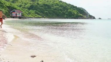 Tayland beach mutlu bir çocuk. Güzel beyaz kum plaj çalışan. Tayland seyahat, tatil, tatil molası promosyon için. Ağır çekimde atış. 