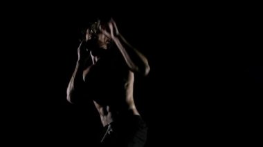 Kaslı adam karanlık arka planda boks